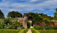 Walled garden at Bignor Park West Sussex with brick archway, manicured hedges and colourful flowers ideal for outdoor wedding photography