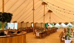 Wedding reception marquee at Bignor Park in West Sussex with elegant table settings and festoon lighting