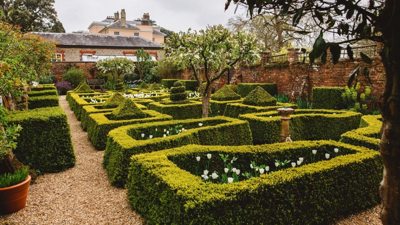 Formal gardens at Bignor Park in West Sussex with manicured hedges and historic house setting