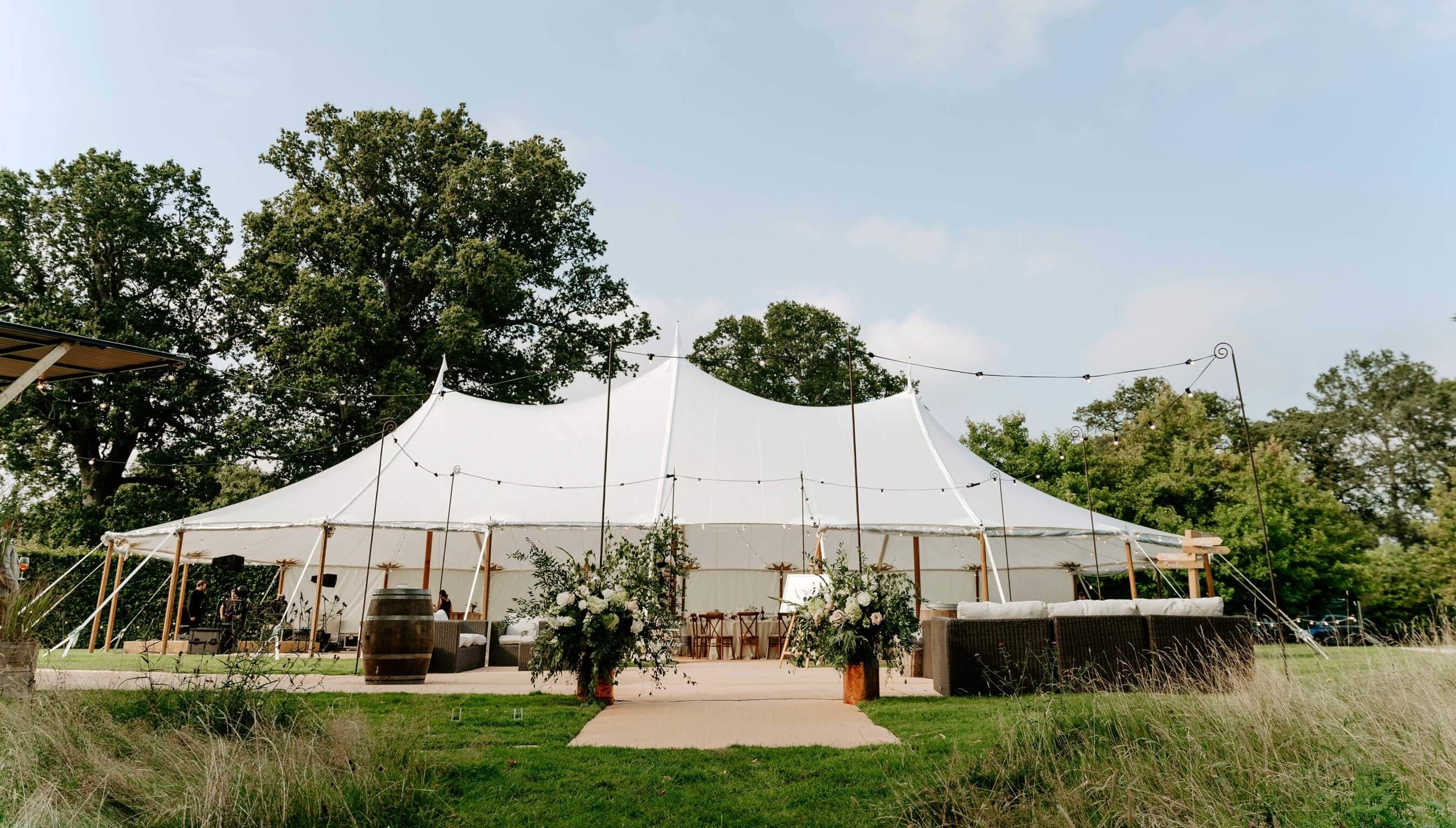 Wedding marquee setup at Bignor Park in West Sussex with outdoor reception space and floral entrance