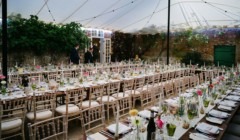 Elegant wedding breakfast setup at Bignor Park courtyard marquee with long tables, chiavari chairs and floral centrepieces in West Sussex