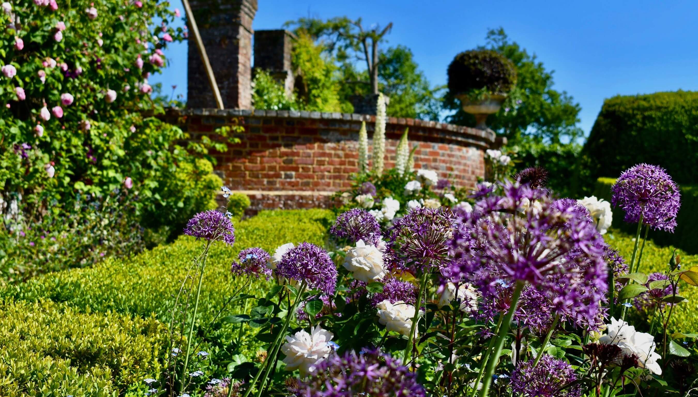 Formal gardens at Bignor Park West Sussex with colourful summer flowers and brick terraces, perfect wedding venue backdrop