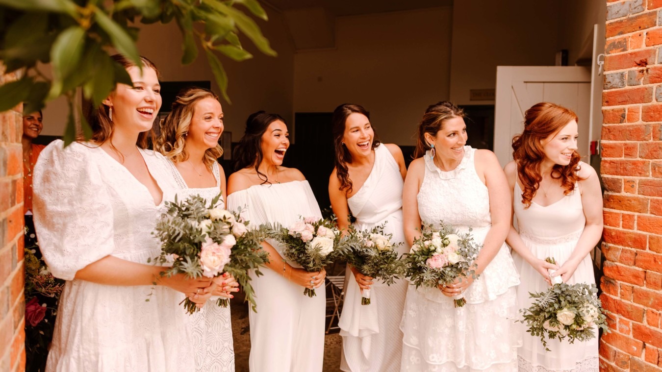 Bridesmaids standing at the door of The Stables at a wedding in Bignor Park West Sussex