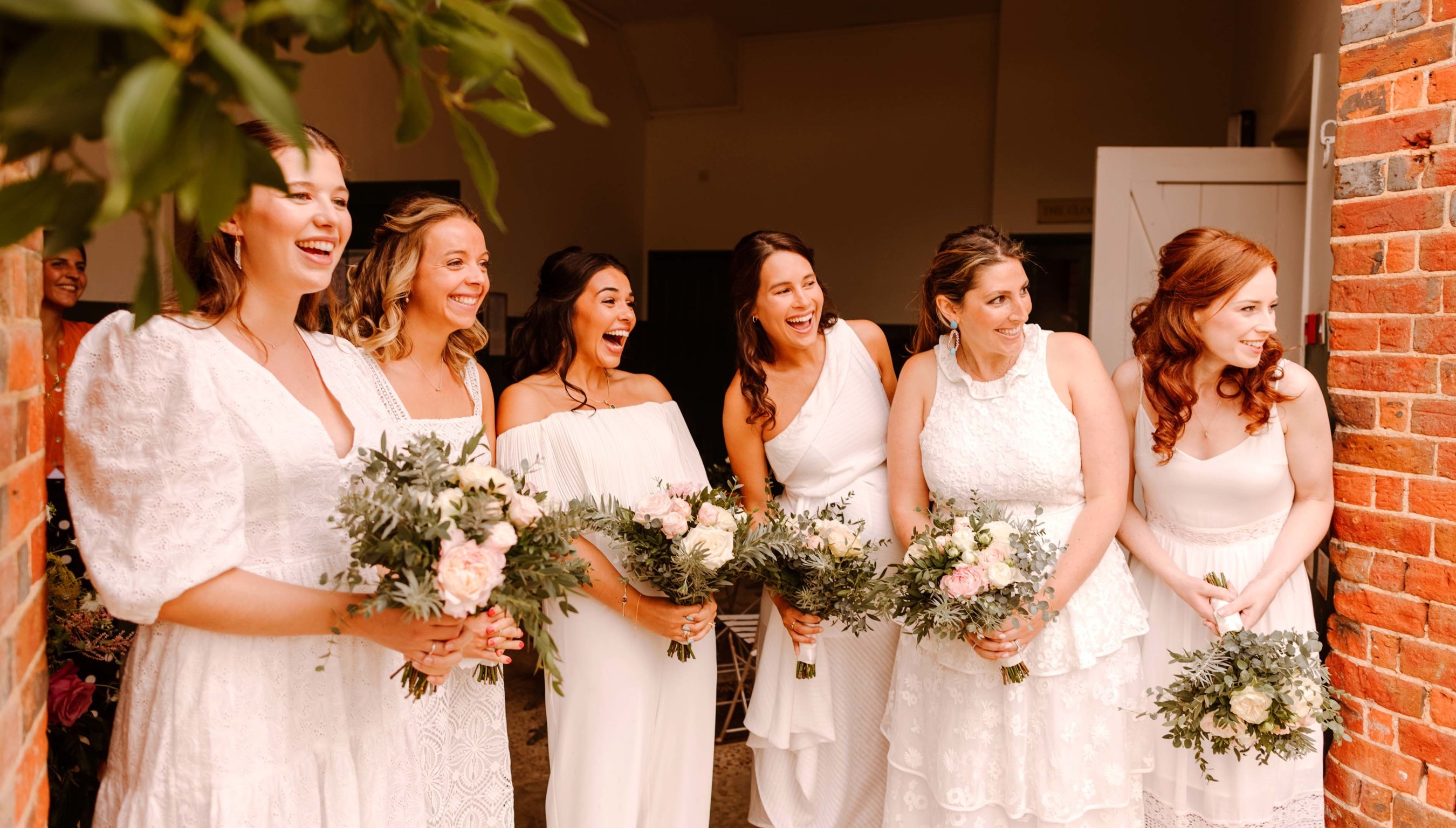Bridesmaids standing at the door of The Stables at a wedding in Bignor Park West Sussex