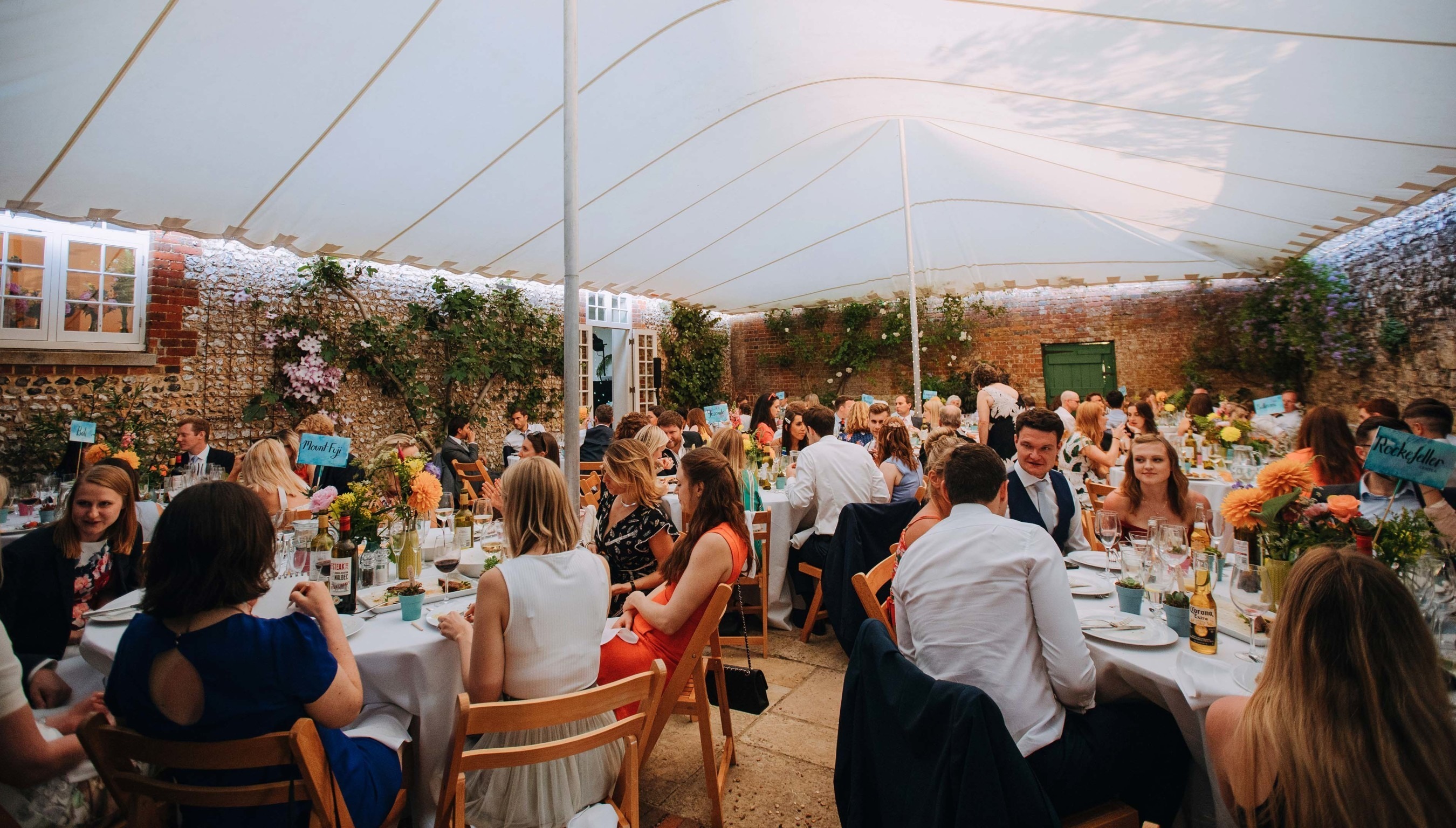 Wedding guest at an outdoor wedding breakfast in the Stables Quadrangle at Bignor Park in West Sussex