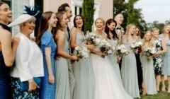 A wedding detail of bride and groom with best men and bridesmaids in from on Bignor Park Estate house on the South lawn