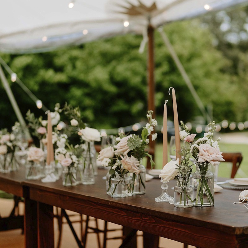 Wedding table styling at Bignor Park marquee in West Sussex with flowers and candles in square format
